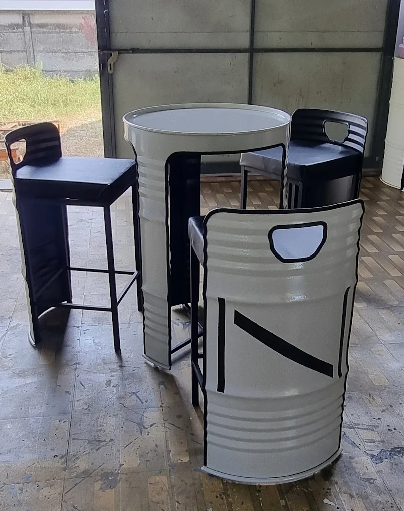 Cream steel-barrel high table and drum chairs with a black bar stool in the Barrels workshop